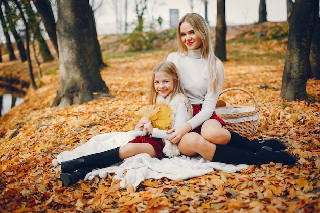 Linda y elegante familia en un parque de otoño