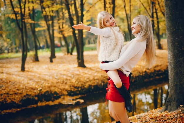 Linda y elegante familia en un parque de otoño