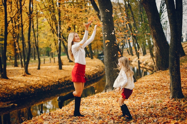 Linda y elegante familia en un parque de otoño