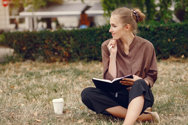 Linda estudiante que trabaja en un parque y usa el cuaderno