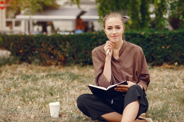 Linda estudiante que trabaja en un parque y usa el cuaderno