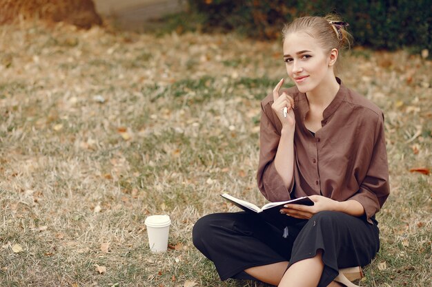 Linda estudiante que trabaja en un parque y usa el cuaderno