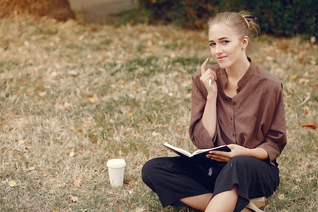 Linda estudiante que trabaja en un parque y usa el cuaderno