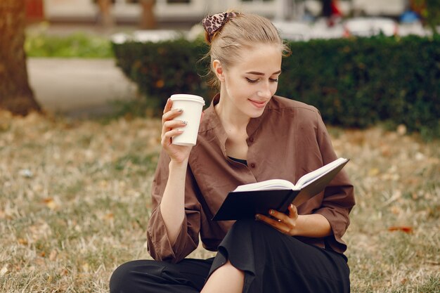 Linda estudiante que trabaja en un parque y usa el cuaderno