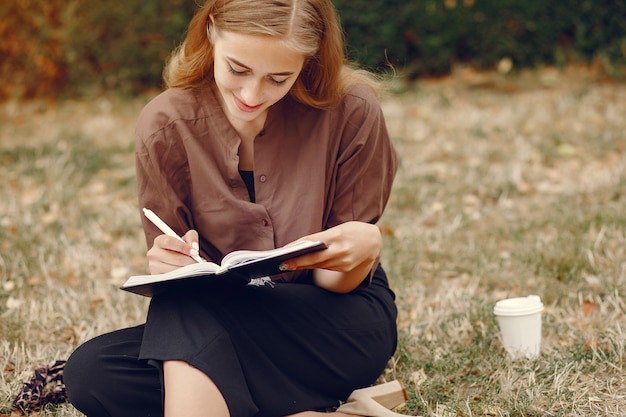 Linda estudiante que trabaja en un parque y usa el cuaderno