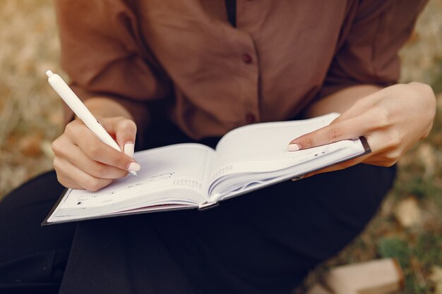 Linda estudiante que trabaja en un parque y usa el cuaderno