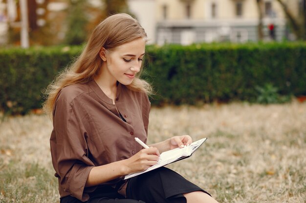 Linda estudiante que trabaja en un parque y usa el cuaderno