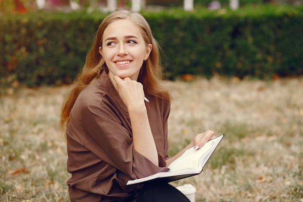 Linda estudiante que trabaja en un parque y usa el cuaderno