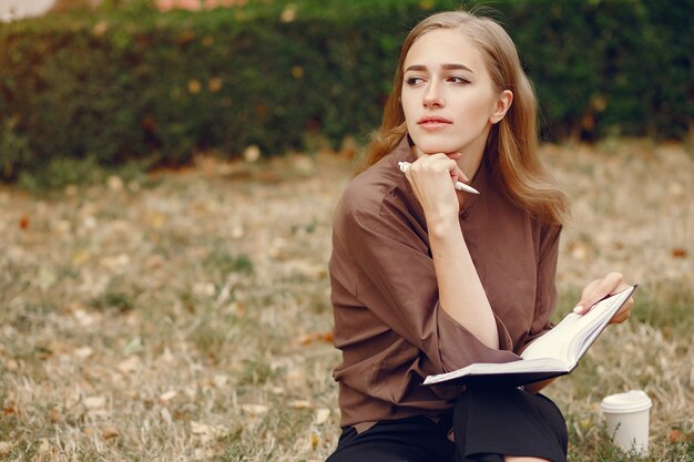 Linda estudiante que trabaja en un parque y usa el cuaderno