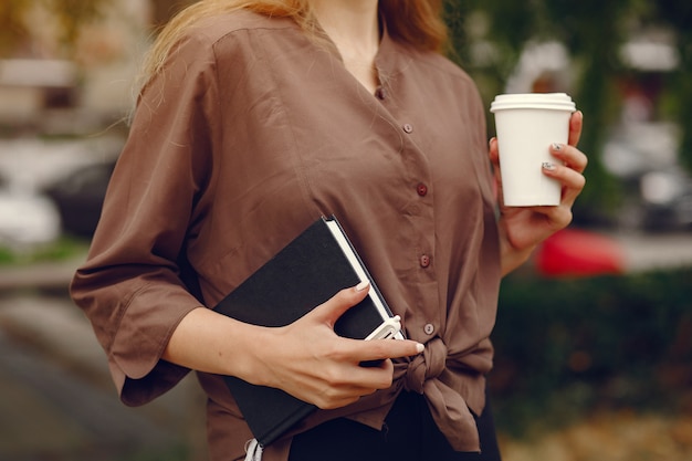 Linda estudiante que trabaja en un parque y usa el cuaderno