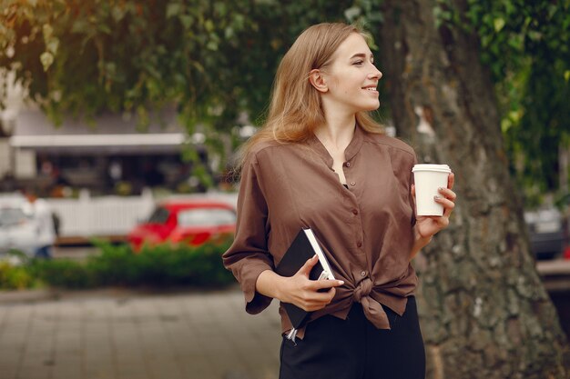 Linda estudiante que trabaja en un parque y usa el cuaderno