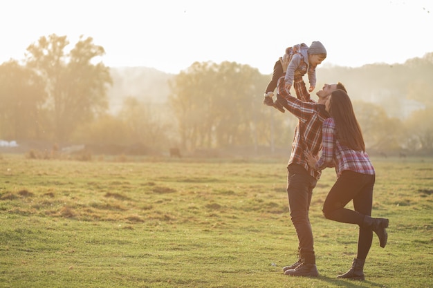 Foto gratuita linda familia caminando en un parque de verano al atardecer