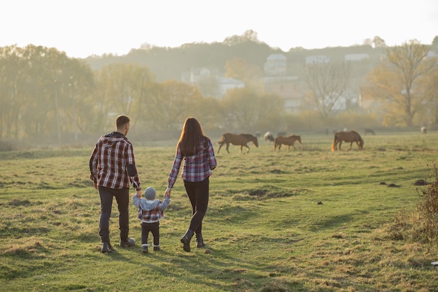 Foto gratuita linda familia caminando en un parque de verano al atardecer