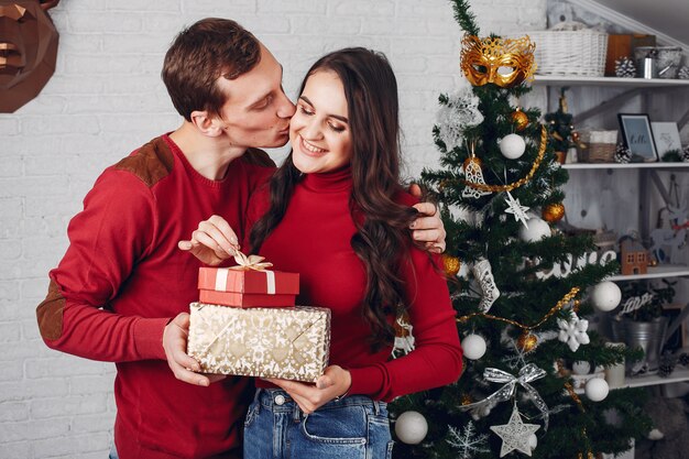 Linda familia en casa cerca del árbol de Navidad