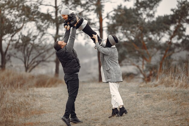 Linda familia jugando en un bosque de primavera