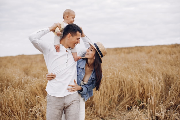 Linda familia jugando en un campo de otoño