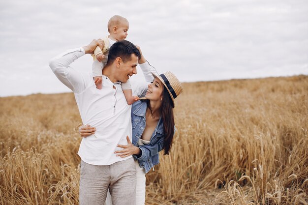 Linda familia jugando en un campo de otoño