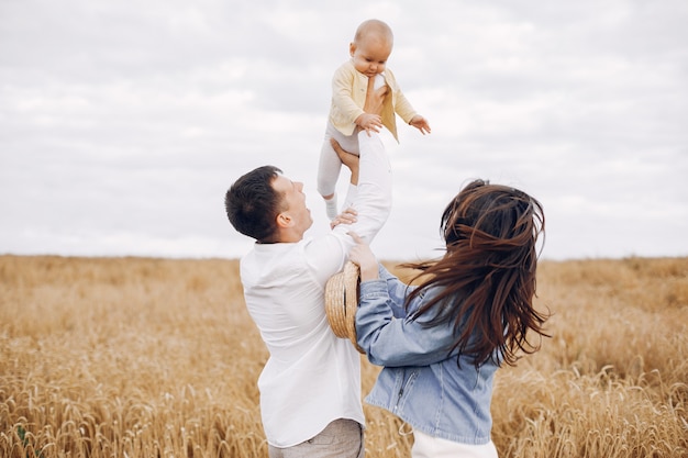 Linda familia jugando en un campo de otoño