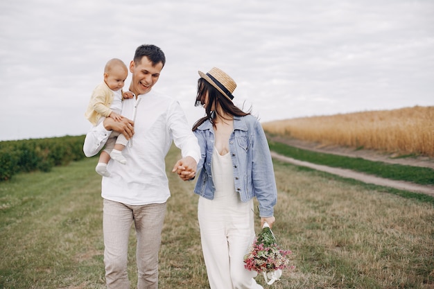 Linda familia jugando en un campo de otoño