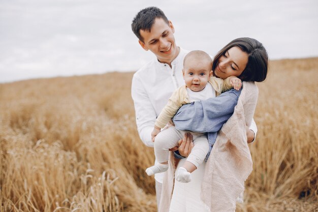 Linda familia jugando en un campo de otoño