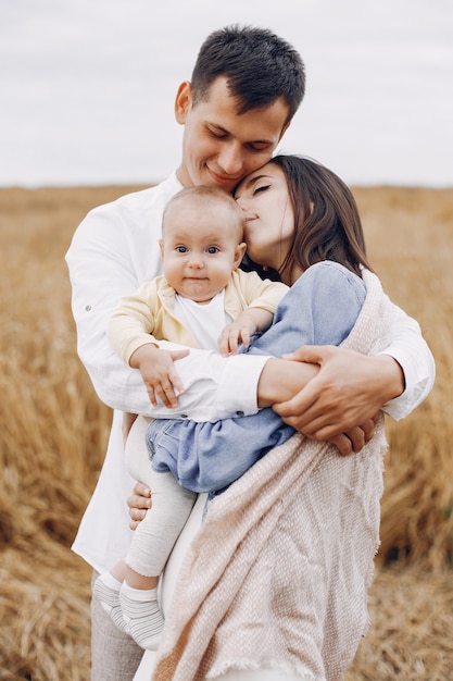 Linda familia jugando en un campo de otoño