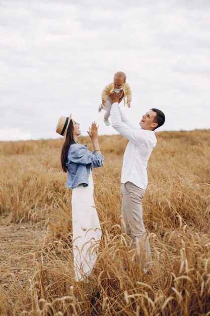 Linda familia jugando en un campo de otoño