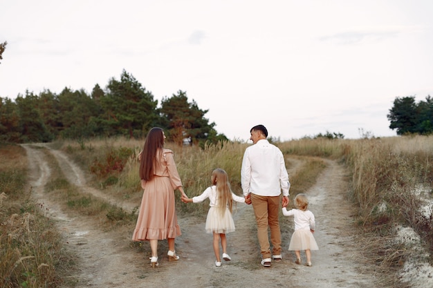 Linda familia jugando en un campo de otoño