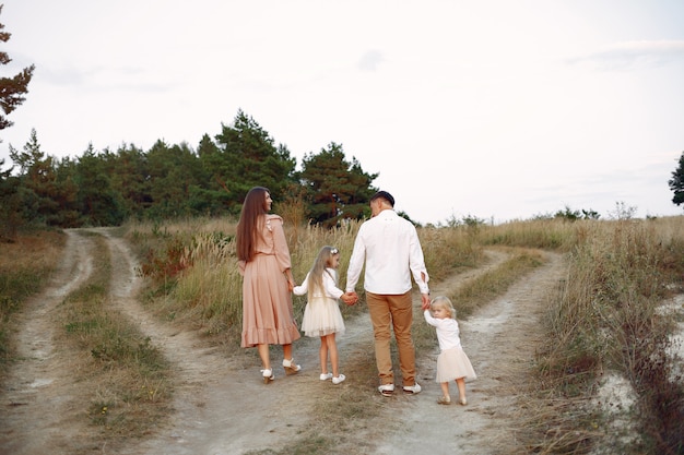 Linda familia jugando en un campo de otoño