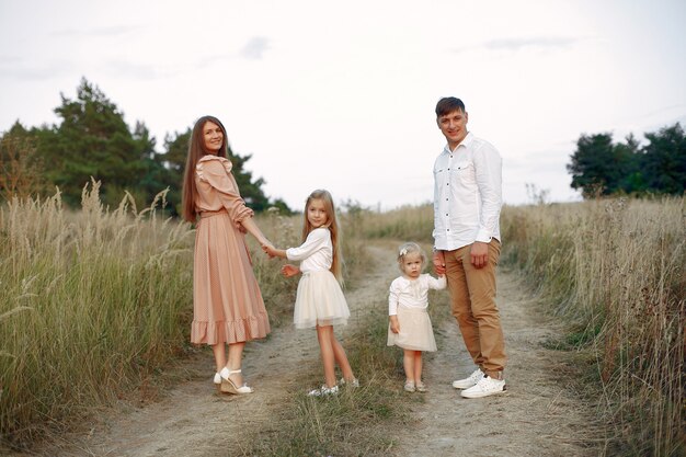 Linda familia jugando en un campo de otoño