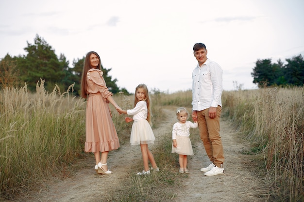 Linda familia jugando en un campo de otoño