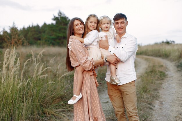 Linda familia jugando en un campo de otoño