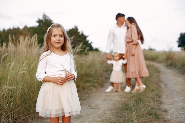 Linda familia jugando en un campo de otoño