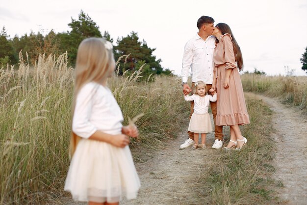 Linda familia jugando en un campo de otoño