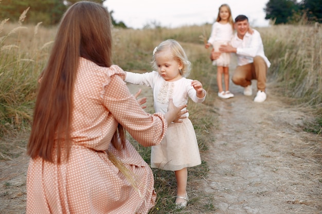 Linda familia jugando en un campo de otoño