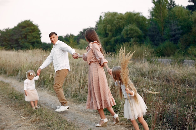 Linda familia jugando en un campo de otoño