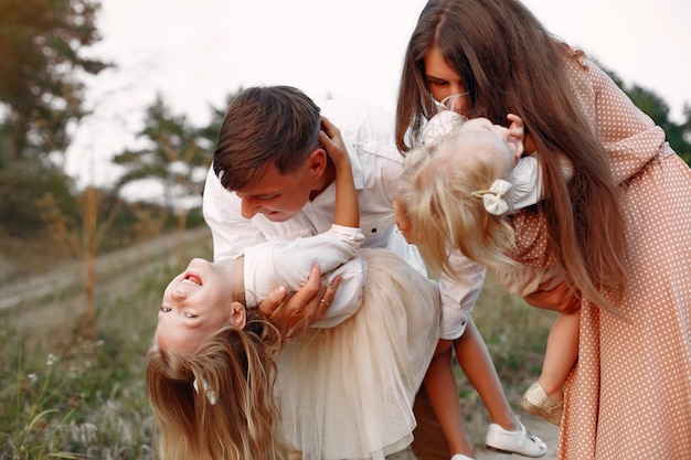 Linda familia jugando en un campo de otoño