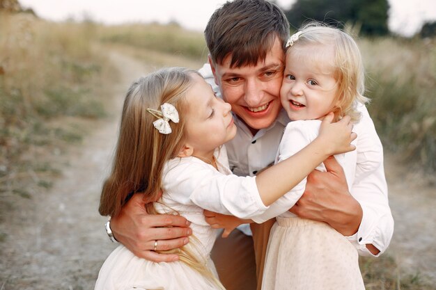 Linda familia jugando en un campo de otoño