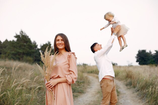 Linda familia jugando en un campo de otoño