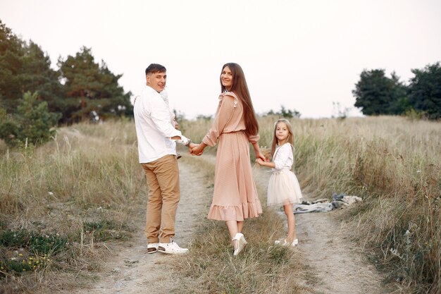 Linda familia jugando en un campo de otoño