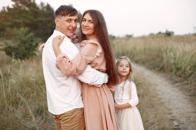 Linda familia jugando en un campo de otoño