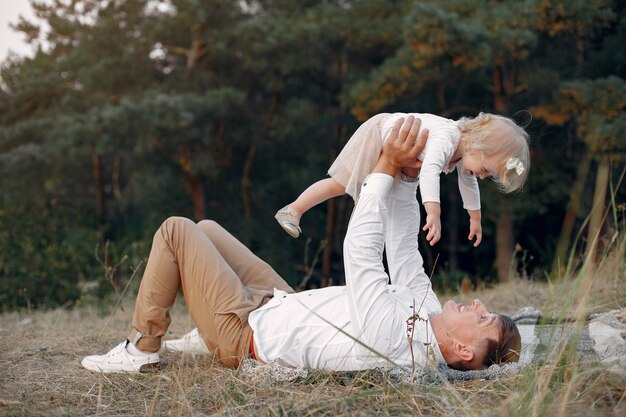 Linda familia jugando en un campo de otoño