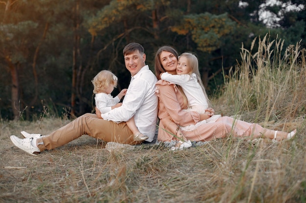 Linda familia jugando en un campo de otoño