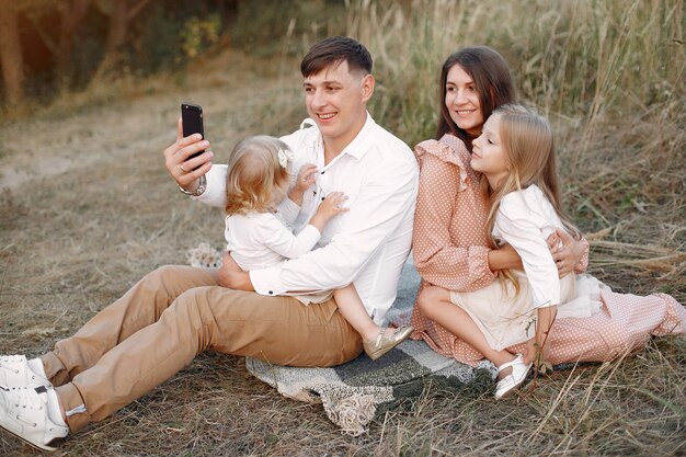 Linda familia jugando en un campo de otoño