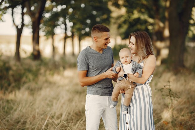 Linda familia jugando en un campo de otoño