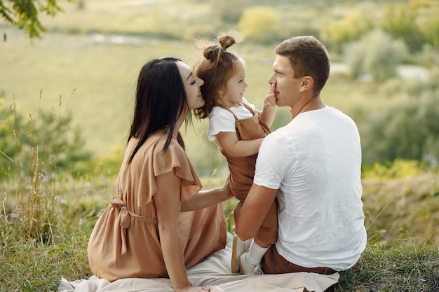 Foto gratuita linda familia jugando en un campo de otoño