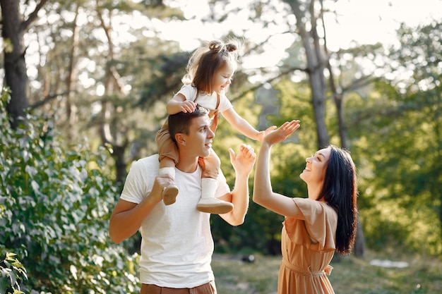 Linda familia jugando en un campo de otoño