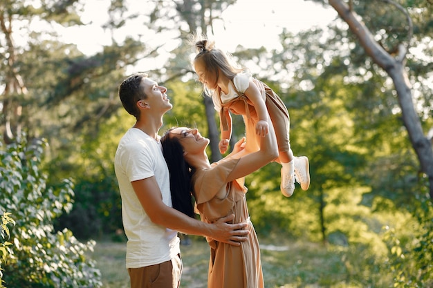 Linda familia jugando en un campo de otoño