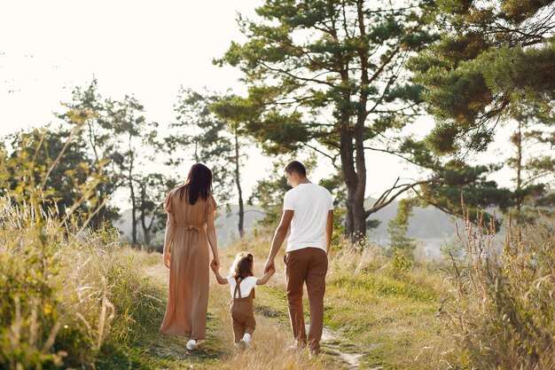 Linda familia jugando en un campo de otoño