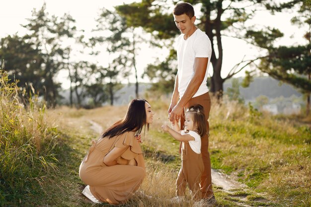 Linda familia jugando en un campo de otoño