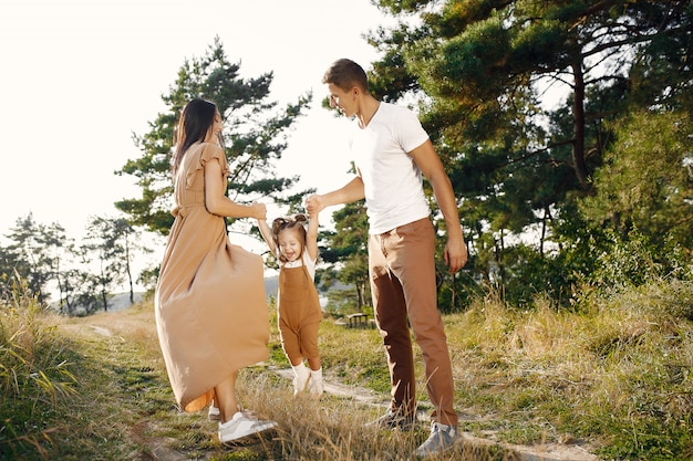 Linda familia jugando en un campo de otoño